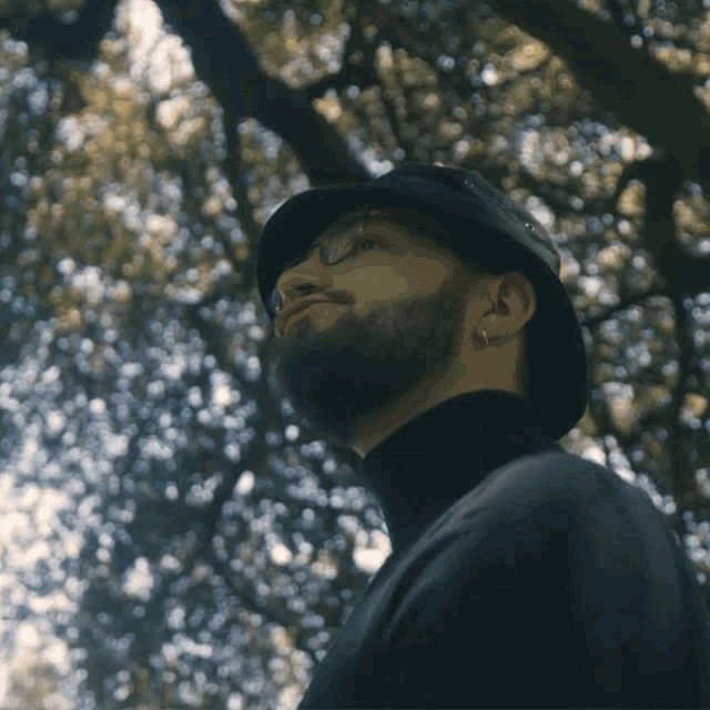 a man with a beard wearing a black hat