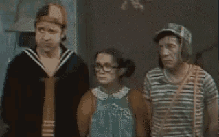 a group of people are standing next to each other and one of them is wearing glasses .
