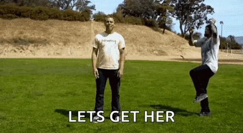 a man and a woman are standing in a grassy field with the words lets get her on the bottom