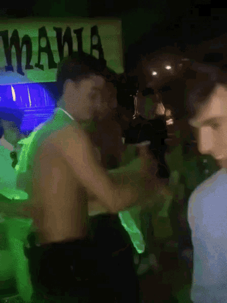 a group of men are dancing in front of a sign that says mafia
