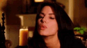 a woman is sitting in front of a candle in a room .