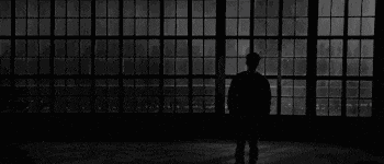 a man is standing in front of a large window .