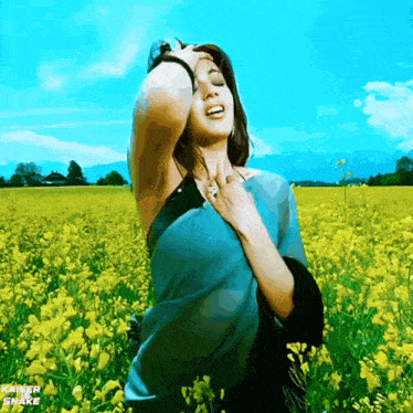 a woman is standing in a field of yellow flowers with kaiser snake written on the bottom left