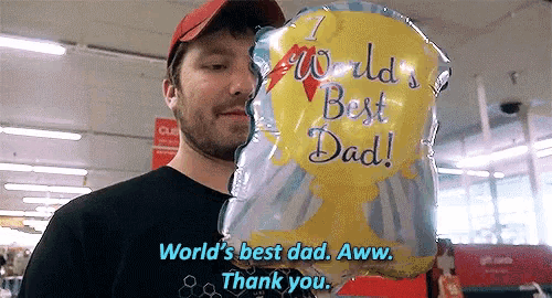 a man holding a world 's best dad balloon