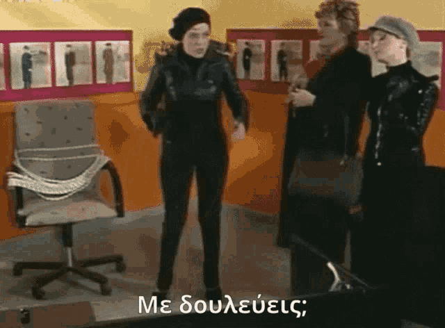 a woman in a black suit is standing next to two other women in black suits .