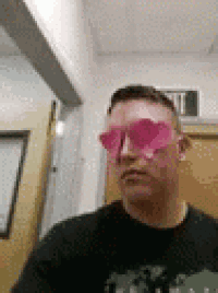 a man is wearing a pair of pink heart shaped sunglasses .