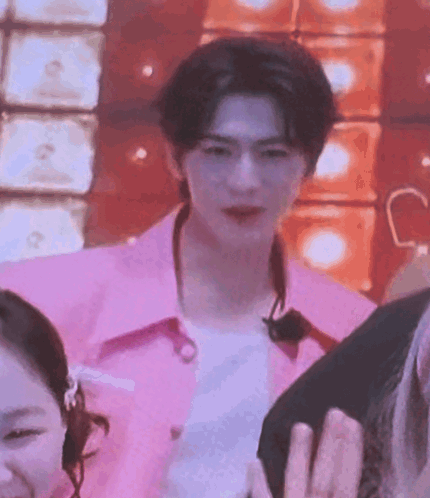 a man in a pink shirt is standing next to a woman in a pink shirt .