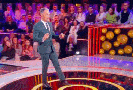 a man in a suit and tie is standing on a stage .