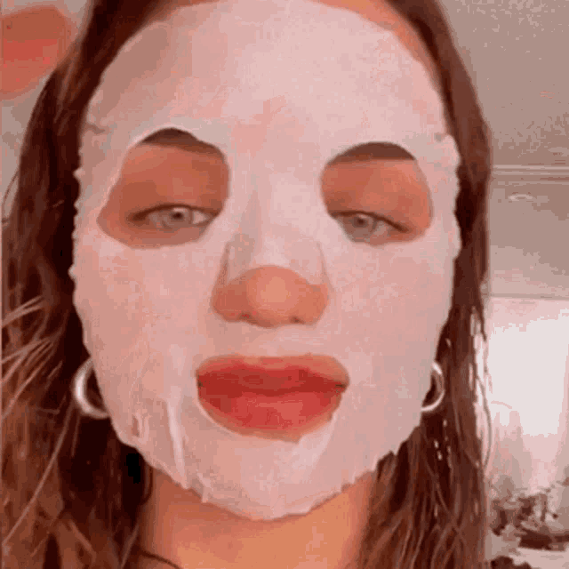 a woman wearing a white face mask with her mouth open