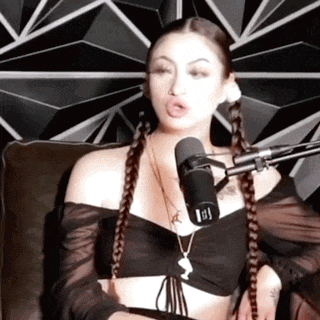 a woman is sitting in front of a microphone with the letter ii on it