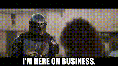 a man in armor is standing next to a woman and talking to her .