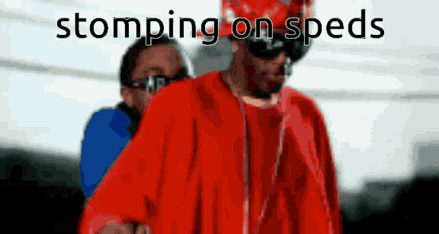 a man in a red jacket with the words stomping on specs above him