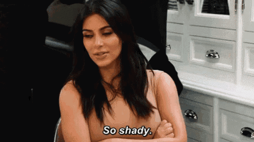a woman is sitting in a chair with her arms crossed and says so shady .