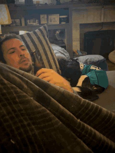 a man laying on a couch holding a beer