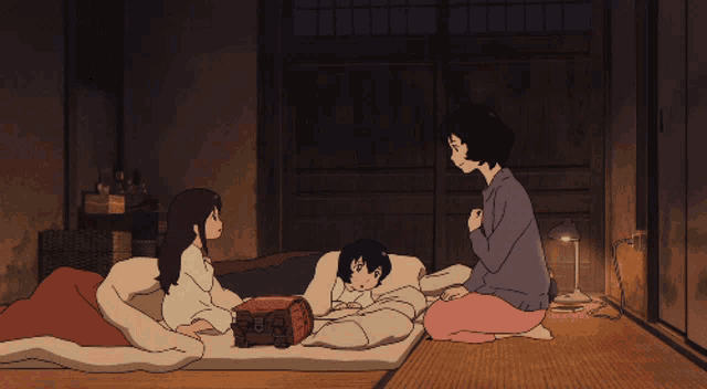 a woman sits on the floor next to two children laying on a bed