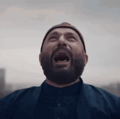 a man with a beard and a hat is screaming with his mouth open