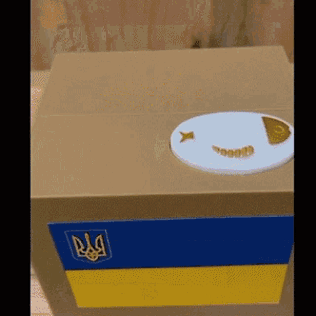 a box with a blue and yellow flag and a fish on it