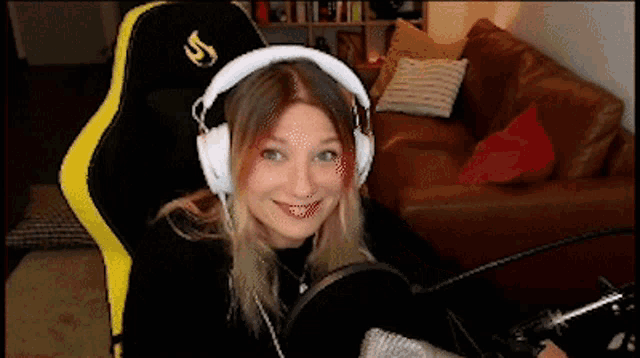 a woman wearing headphones is sitting in a yellow and black chair
