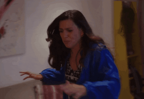 a woman in a blue jacket is dancing