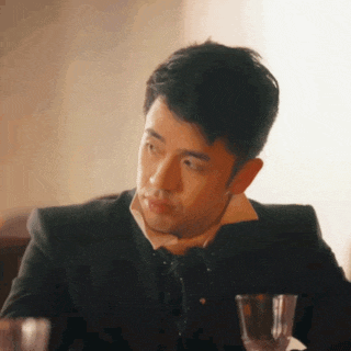 a man in a suit and tie is sitting at a table