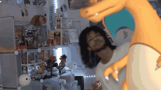 a man in a white shirt is standing in front of a shelf full of funko pop figures
