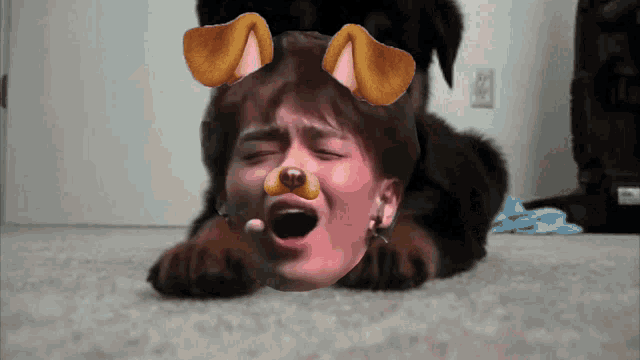 a picture of a person laying on the floor with a dog 's face on their face