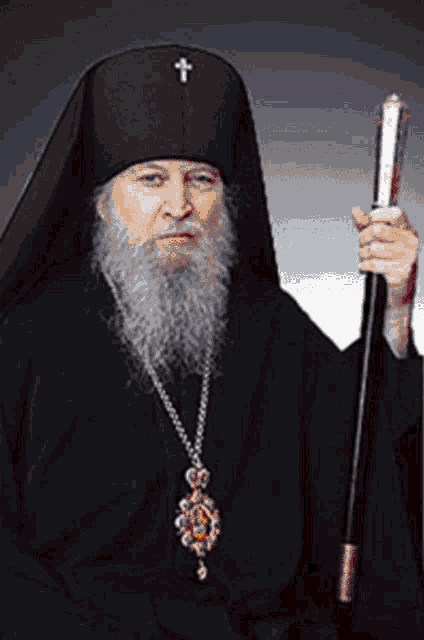 a man with a beard and a cross on his hat