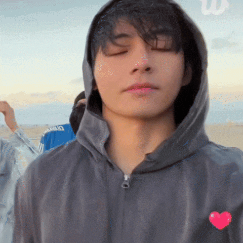 a young man wearing a hooded jacket with a heart on the front