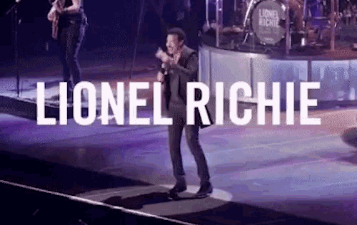 a man singing on stage with the name lionel richie written above him