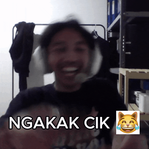 a blurry picture of a man with headphones and the words ngakak cik