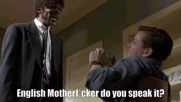 a man in a suit and tie is talking to another man in a chair with the words english motherfucker do you speak it