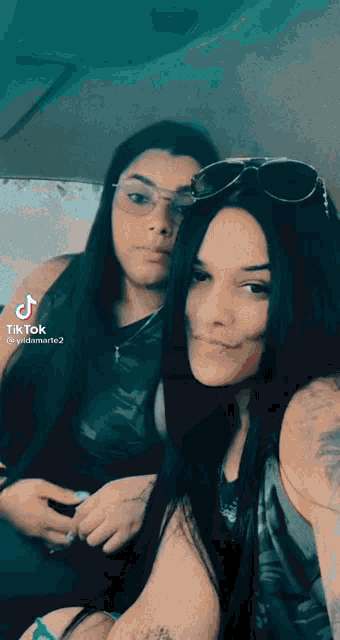 two women are posing for a picture with tik tok written on the bottom
