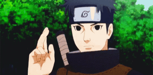 a young boy wearing a headband and holding a sword is pointing his finger up .