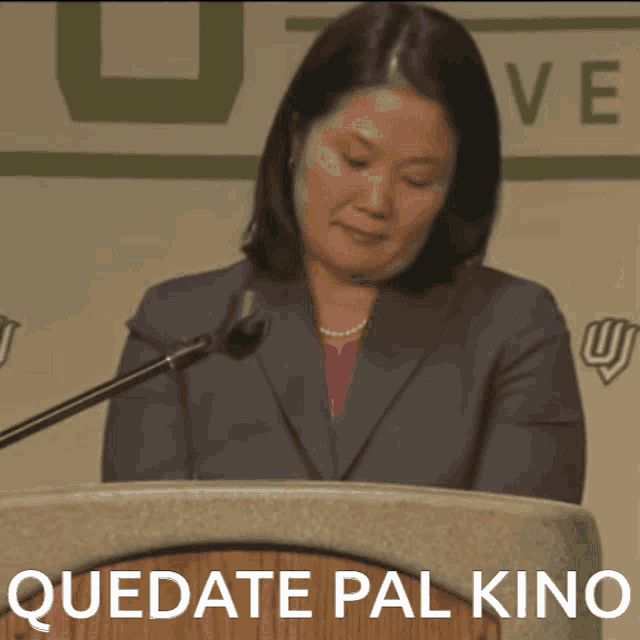 a woman stands behind a podium with quedate pal kino written on the bottom
