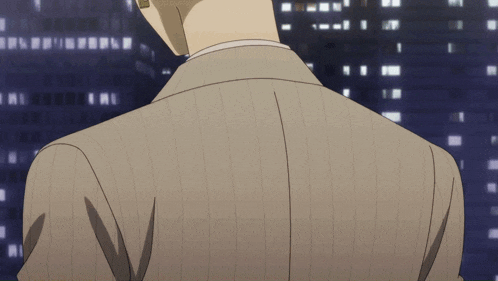 a man in a suit is standing in front of a city skyline at night
