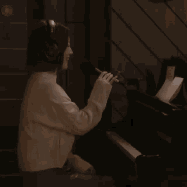 a woman wearing headphones singing into a microphone while playing a piano