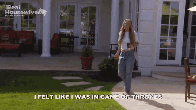 a woman walking in front of a house with the words i felt like i was in game of thrones written below her