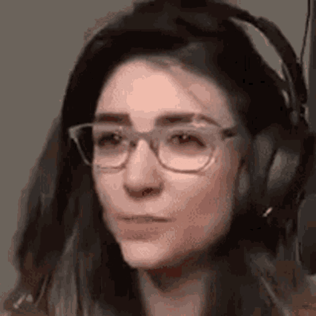 a close up of a woman wearing headphones and glasses .
