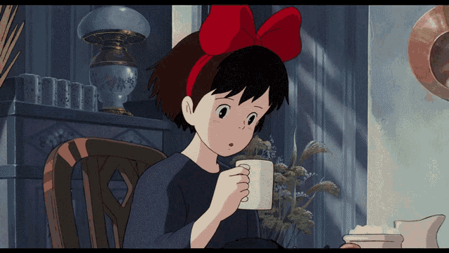 a girl with a red bow on her head is holding a cup