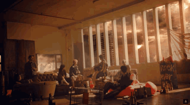 a group of people are gathered in a room with a sign that says rock music