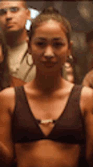 a woman in a bikini top is standing in a crowd .