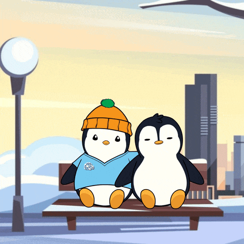 a couple of penguins sitting on a bench with one wearing a shirt that says iceland on it