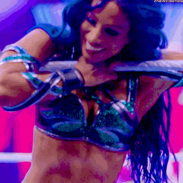 a woman in a bikini is holding a sword in her hand and smiling .