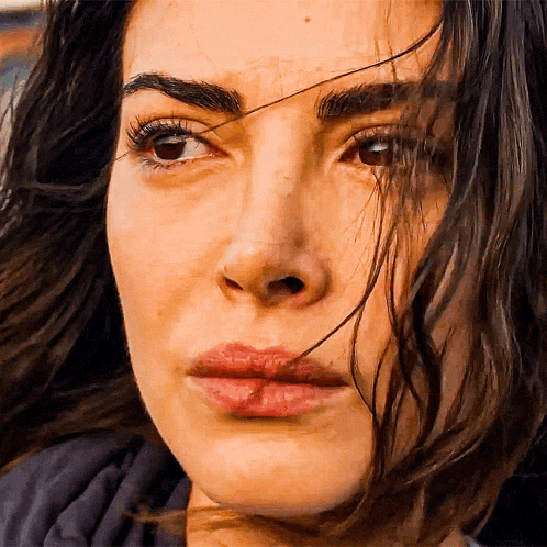 a close up of a woman 's face with a slight smile on her face