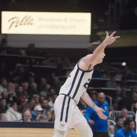 a basketball player with the number 5 on his jersey stands on the court