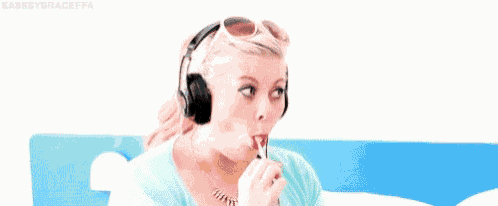 a woman wearing headphones and sunglasses is listening to music .