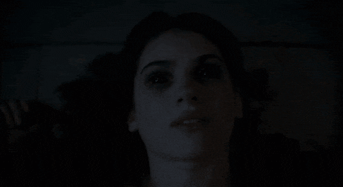 a close up of a woman 's face with a dark background
