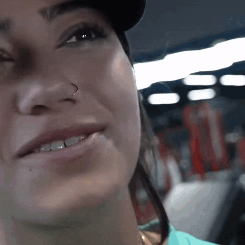 a close up of a woman 's face with a nose ring on it