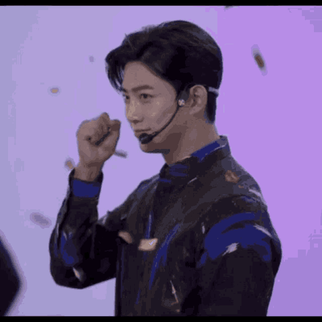a young man wearing a headset and a black jacket