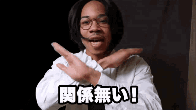 a man wearing glasses and a headset is crossing his arms in front of a black background with chinese characters on it